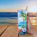 Woman holding floral beach tumbler outdoors at sunny table at the beach